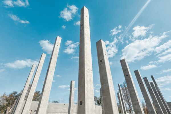 Wysokie słupy prefabrykowane ustawione na budowie, widok od dołu