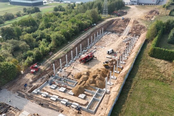 Pierwsze słupy prefabrykowane osadzone w fundamentach hali, widok z drona