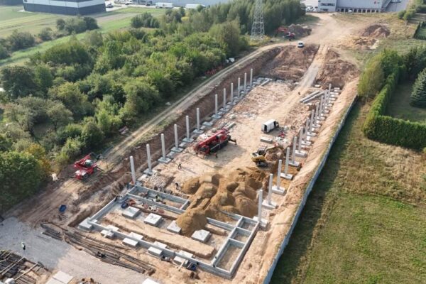 Słupy prefabrykowane w dwóch rzędach na placu budowy hali z lotu ptaka