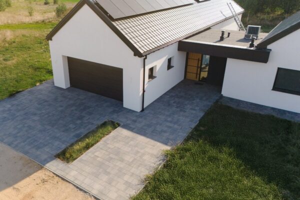 Podjazd z szarej kostki brukowej przed garażem nowoczesnego domu, widok z góry