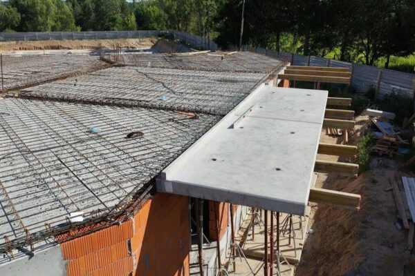 Płyty balkonowe na stemplach przy krawędzi zbrojonego stropu budynku